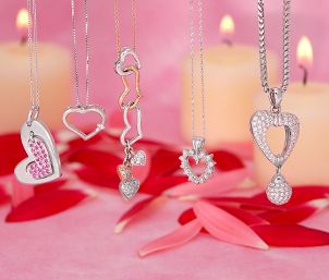 Heart necklaces dangling in front of candles